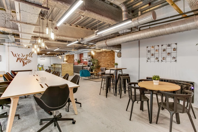 Coworking space at Venaspace Exeter showcasing a long white rectangular table with black leather 