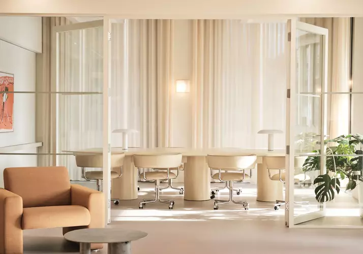 Meeting room at FORA Gridiron Building with cream chairs around a cream table 