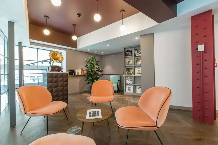 Breakout Space at FORA The Bloomsbury Building in London with three orange chairs 