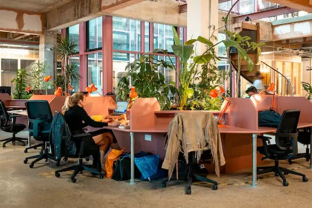 Co-working Space at Oru Space in Sutton showcasing wooden workstation cubicles with black office chairs