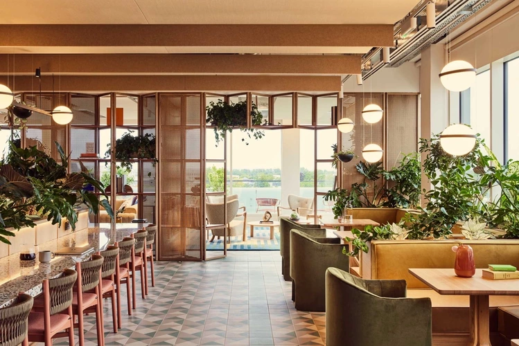 Balcony and coworking workspace area at FORA 20 Station Road Cambridge office space filled with green plants
