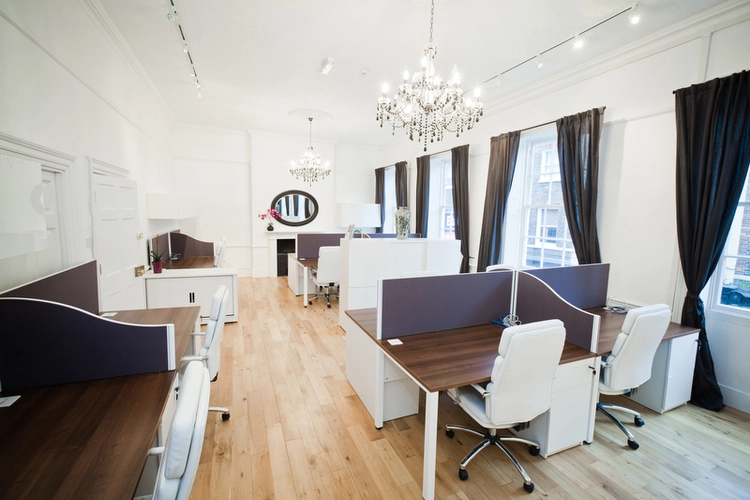 Office Space at Blake House showcasing dark wood workstations with white trimmings and white leather chairs