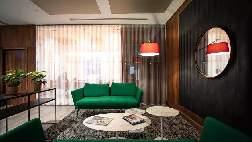 Breakout Space at Gilbanks One Park Row showcasing a green couch with three white round 