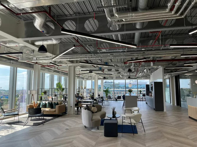 Large open coworking space with floor to ceiling windows and lots of natural light at Venture X White City