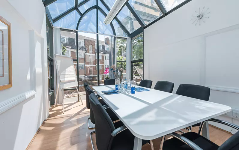 Meeting room in a glass greenhouse with a whiteboard in the backroung at Lentaspace Hyde Park House office space