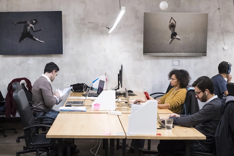 3 people sitting at a cluttered desk working on their laptops at La Vaca Coworking - on Tally Maket.jpg