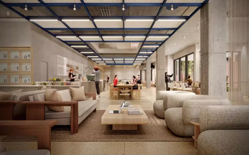 Breakout Space and Cafe at The Jellicoe in London showcasing beige couches with a wooden coffee table in front of a cafe 