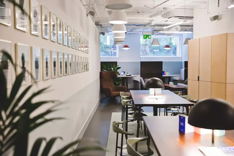 Office space at FORA Lloyds Avenue in London brown desk with green chairs and black lamps 