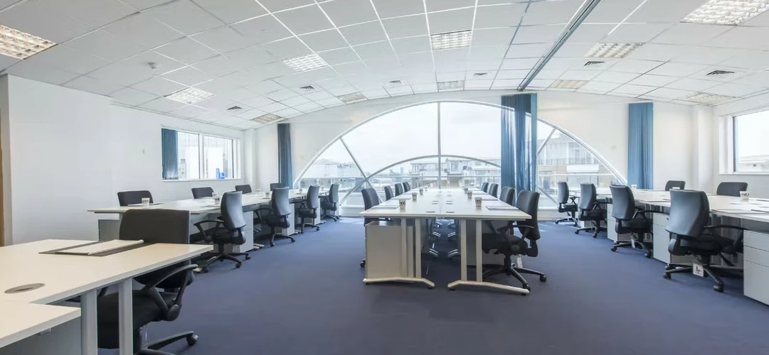 Large office space at the Lentaspace St Katherines Dock office space with many chairs around desks and a large window at the back