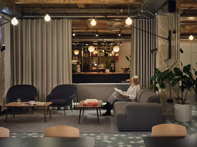 Breakout room at Albert House with a turquoise wall and two black chairs and a grey couch